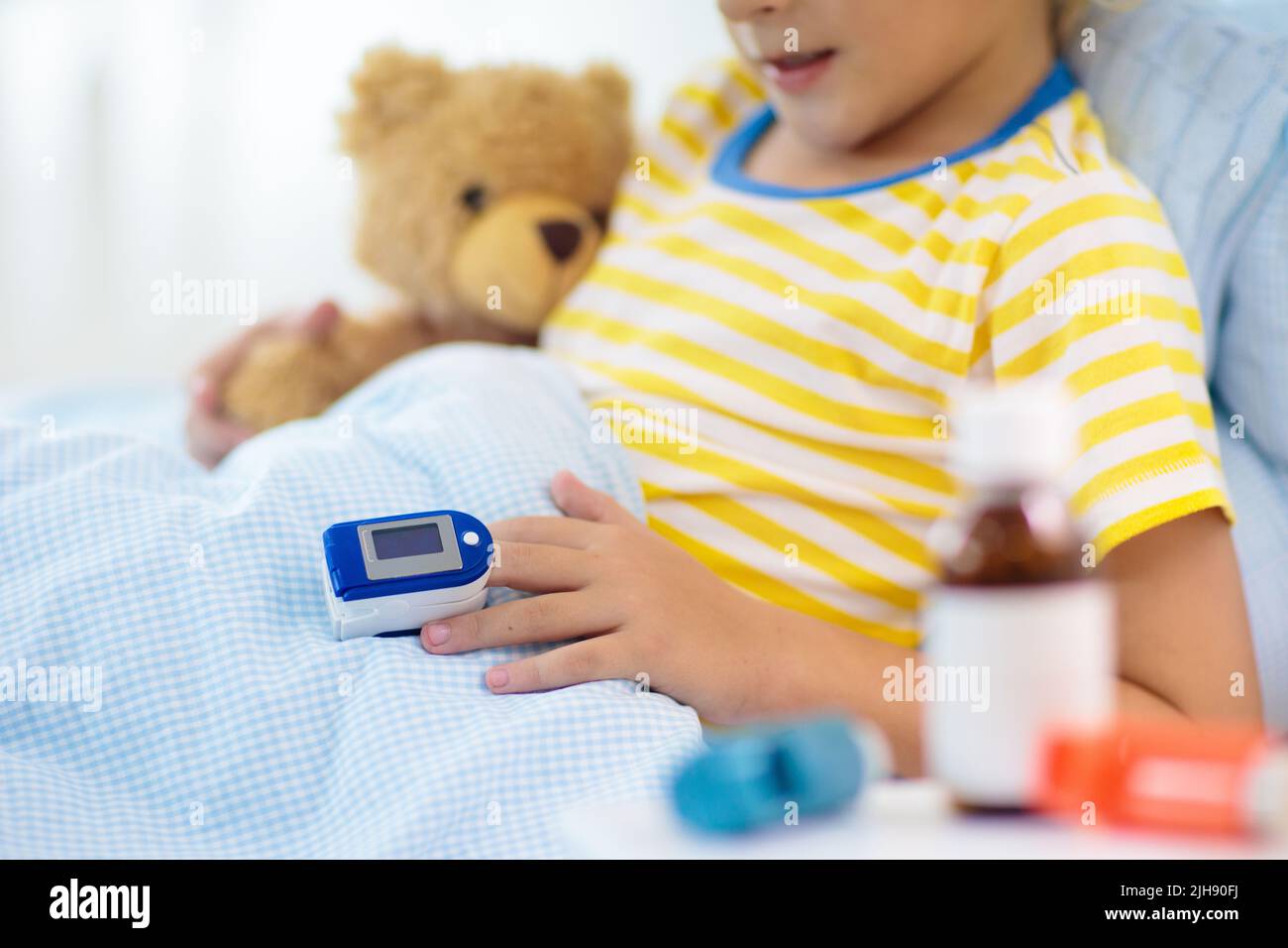 Sick little boy with pulse oximeter on his finger. Asthma treatment. Ill  child lying in bed. Unwell kid with chamber inhaler, cough medicine Stock  Photo - Alamy
