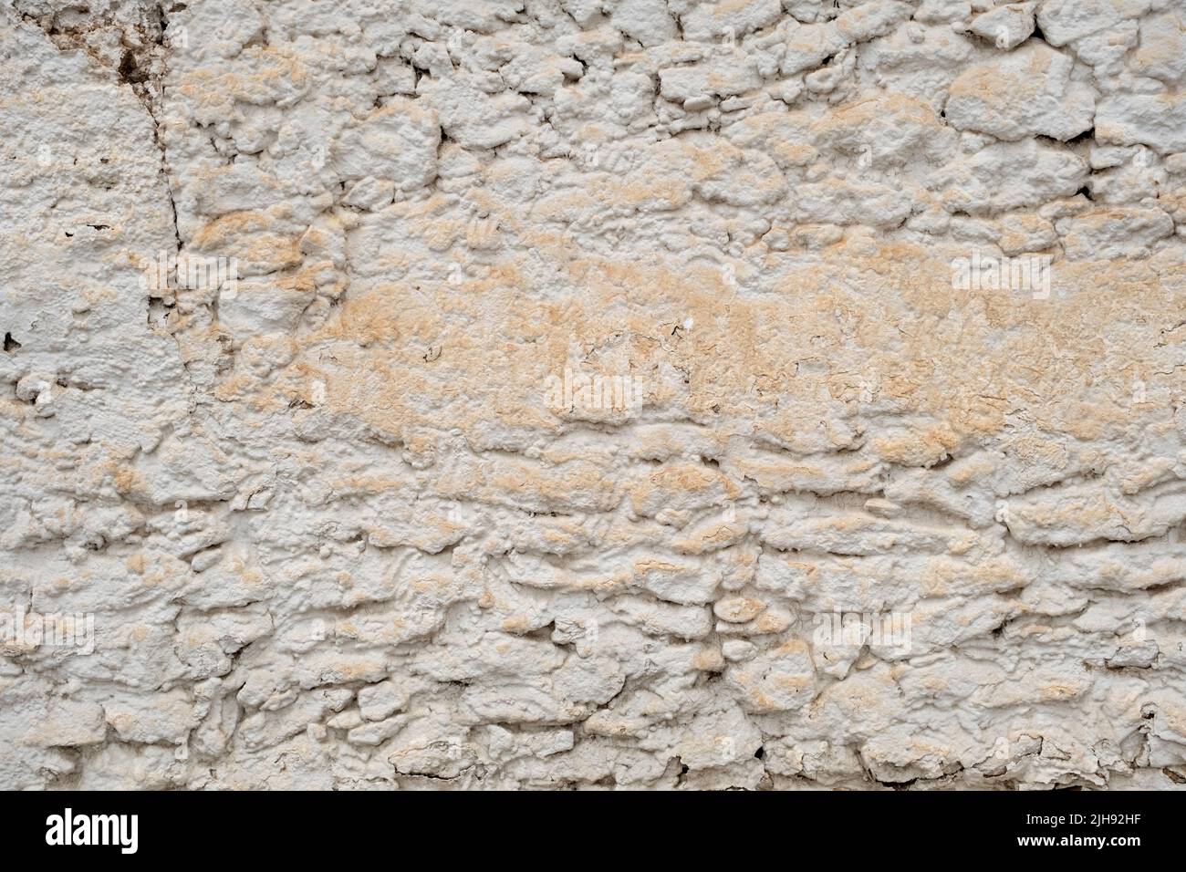 Old traditional limewashed stone wall, white rustic background or texture Stock Photo