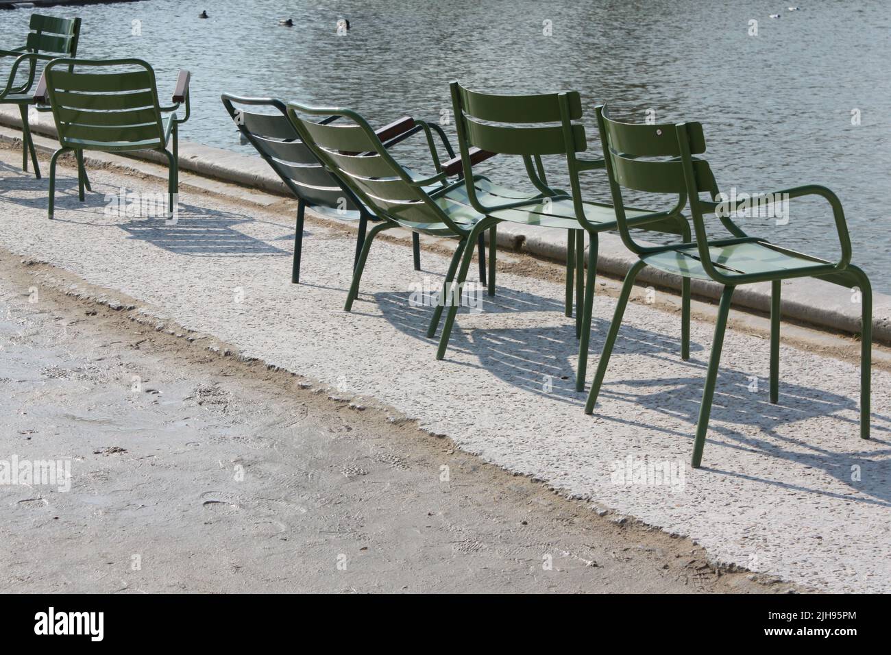 Green lawn chairs in Luxembourg Garden in Paris, France around a pool. Stock Photo