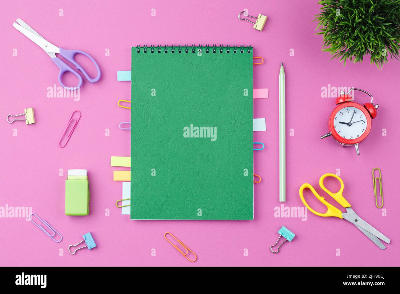 Green notepad with stationery on a pink background Stock Photo