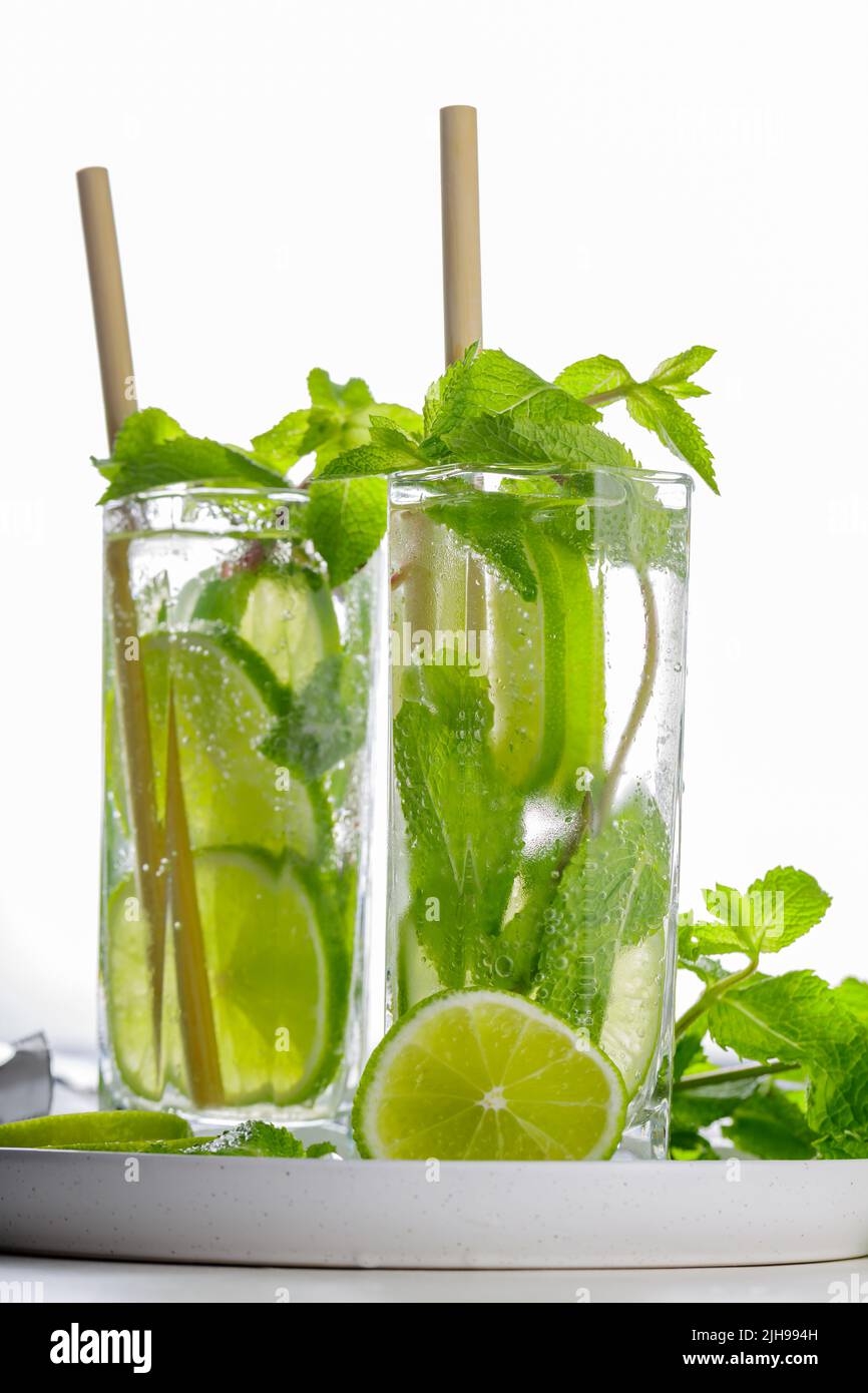 Mojito cocktail and bar tools on a white background. Two glasses of