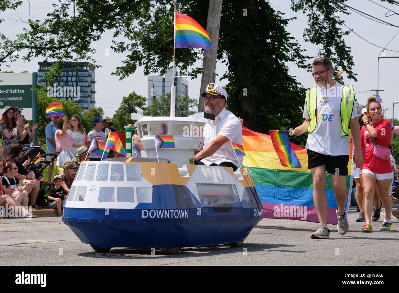 Halifax, Canada. July 16th, 2022. A mini Ferry part of the Downtown Dartmouth float in the 2022 Halifax Pride Parade waves to some of the thousands spectators that lined the course. The Parade returns through the street of the city after two years absence. Credit: meanderingemu/Alamy Live News Stock Photo