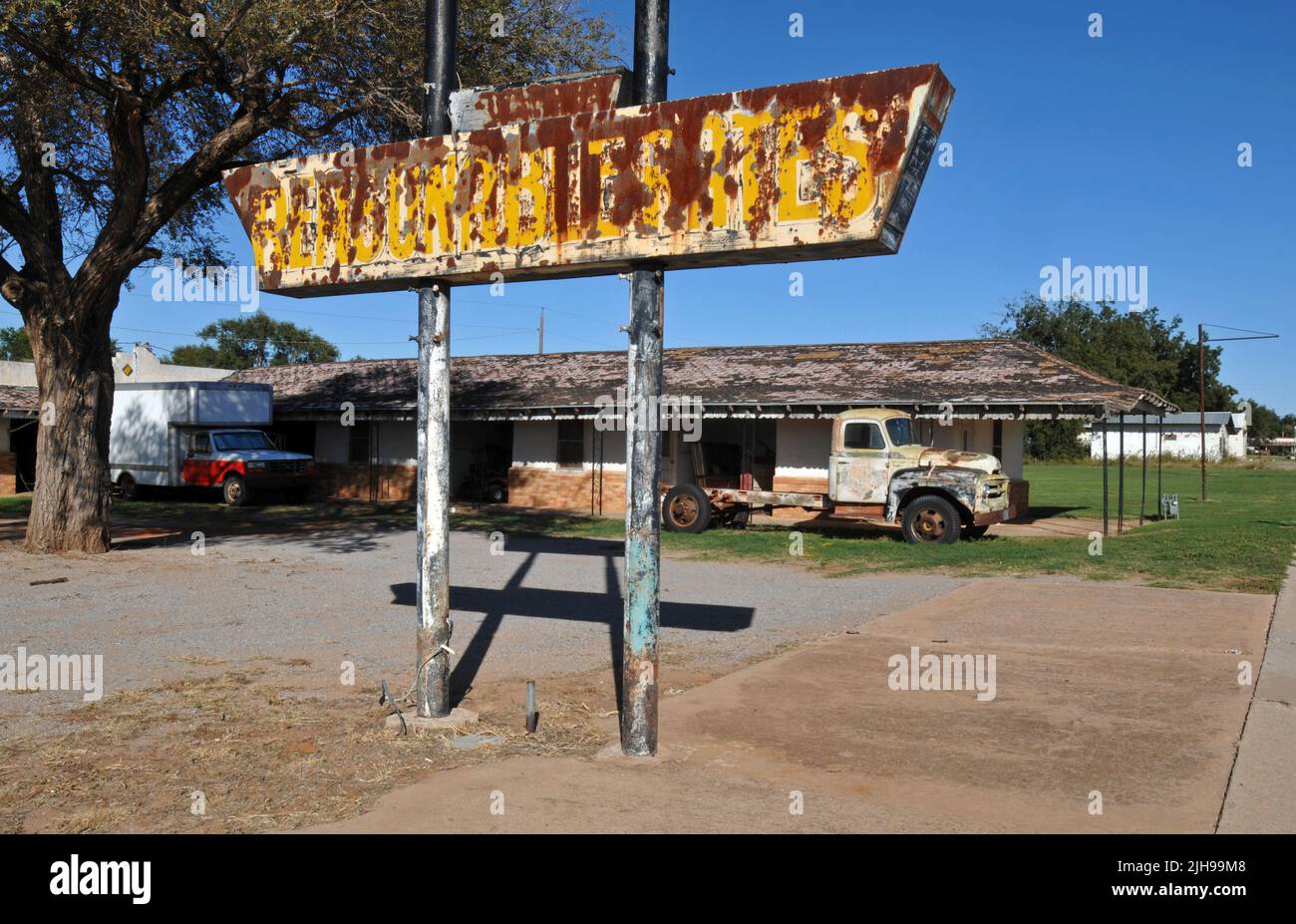 A rusting sign advertising "Reasonable Rates" stands near an old truck at the former Elm Motel in the small Route 66 city of Erick, Oklahoma. Stock Photo