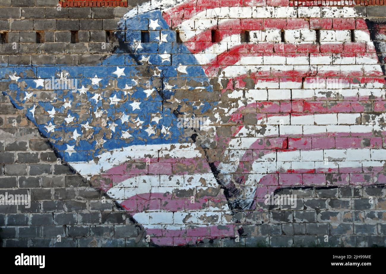 A painted American flag mural adorns the brick wall of a building in the Route 66 city of Erick, Oklahoma. Stock Photo