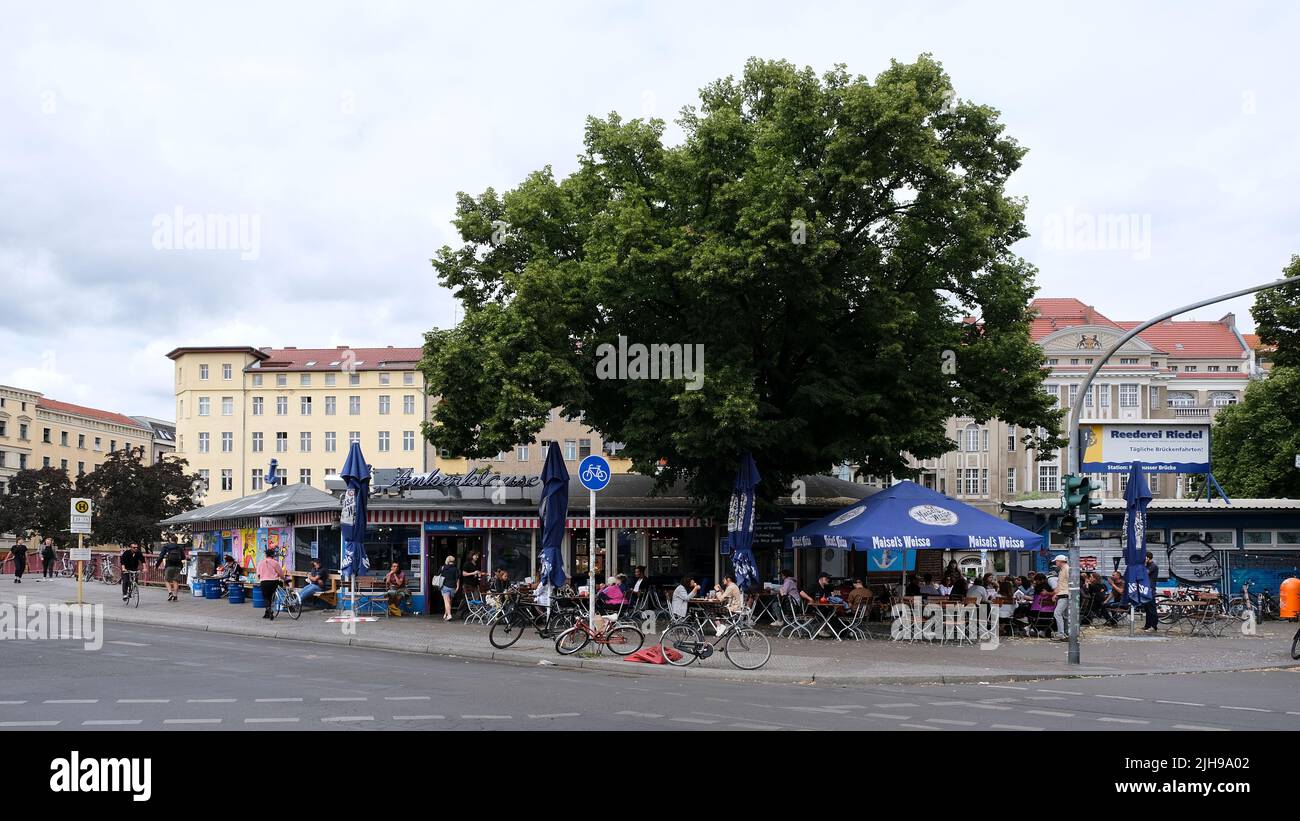 rlin, Germany, July 6, 2022, 'Ankerklause', popular scene pub in Kreuzberg at Kottbusser Brücke with residential buildings on Planufer in the backgrou Stock Photo