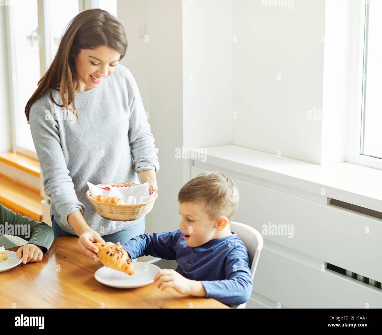 child son mother family happy food breakfast home brother kid childhood parent morning meal love Stock Photo