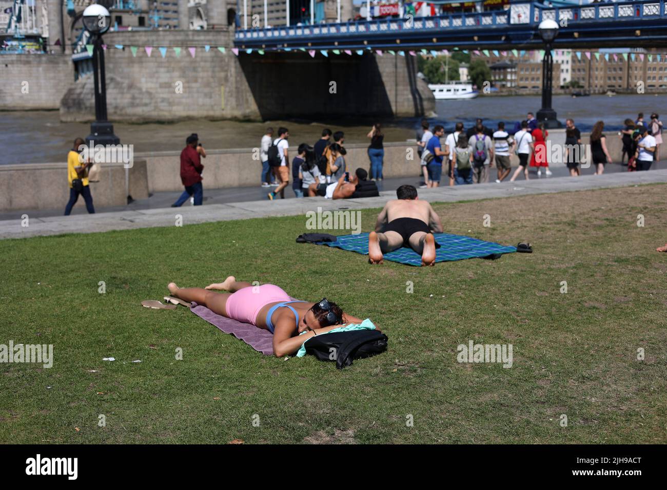 People are seen enjoying the hot weather at London Bridge area. UK is embracing the hottest weather ever due to the impact from climate changes. Temperatures are expected to raise to 40 degrees in London on Monday. The Met Office has issued a red weather alert and warning citizen about the risk of death at extreme hot weather. Stock Photo