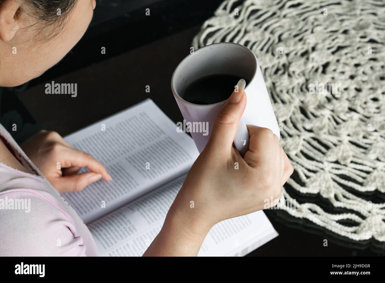 beautiful latina woman, college student reading a book while holding a