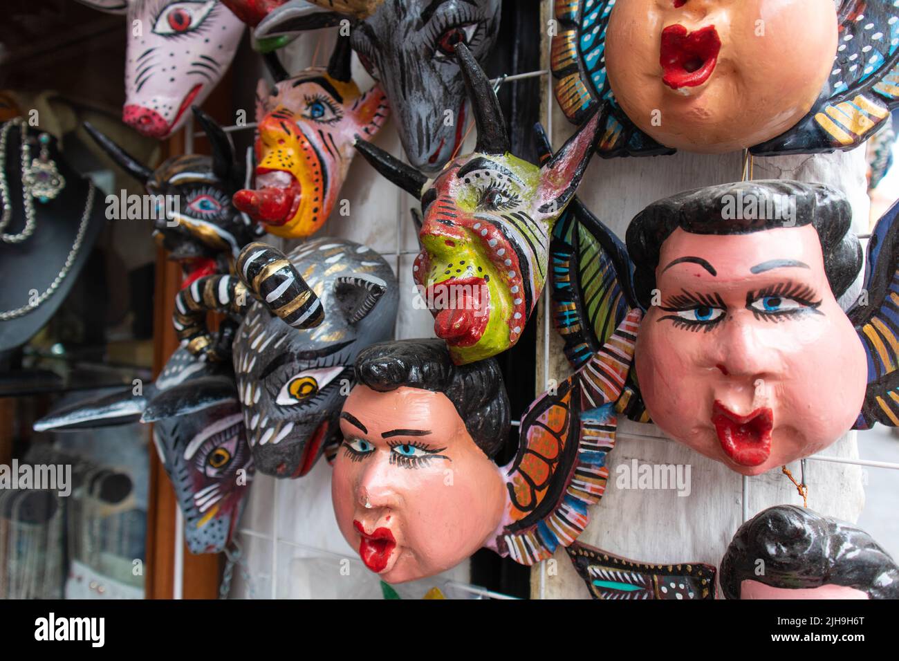 traditional mexican mask adornment, angels and demons pottery colorful carnival masks in a market in Puebla city, Mexico Stock Photo