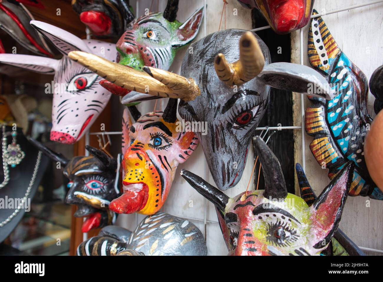 traditional mexican mask adornment, angels and demons pottery colorful carnival masks in a market in Puebla city, Mexico Stock Photo