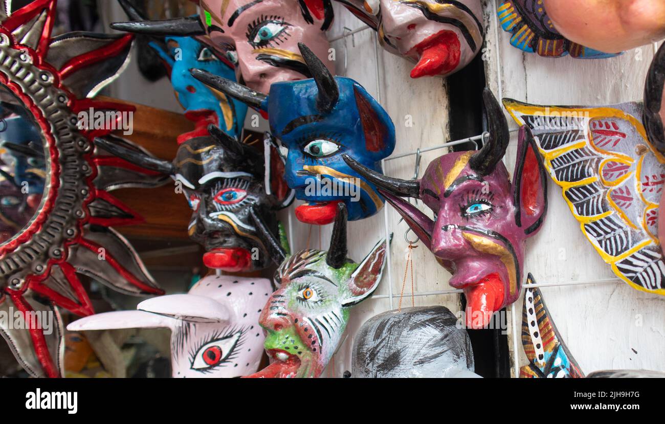 traditional mexican mask adornment, angels and demons pottery colorful carnival masks in a market in Puebla city, Mexico Stock Photo