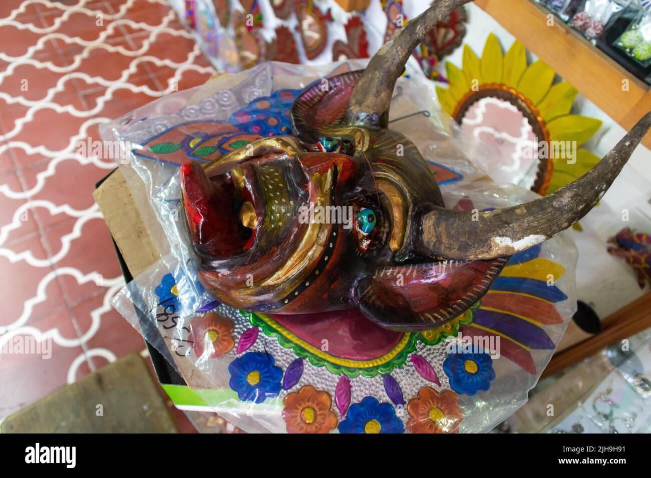 Traditional mexican carnival day of the dead demon devil dark red mask talavera typical ceramic pottery at sale in a market in Puebla City, México Stock Photo