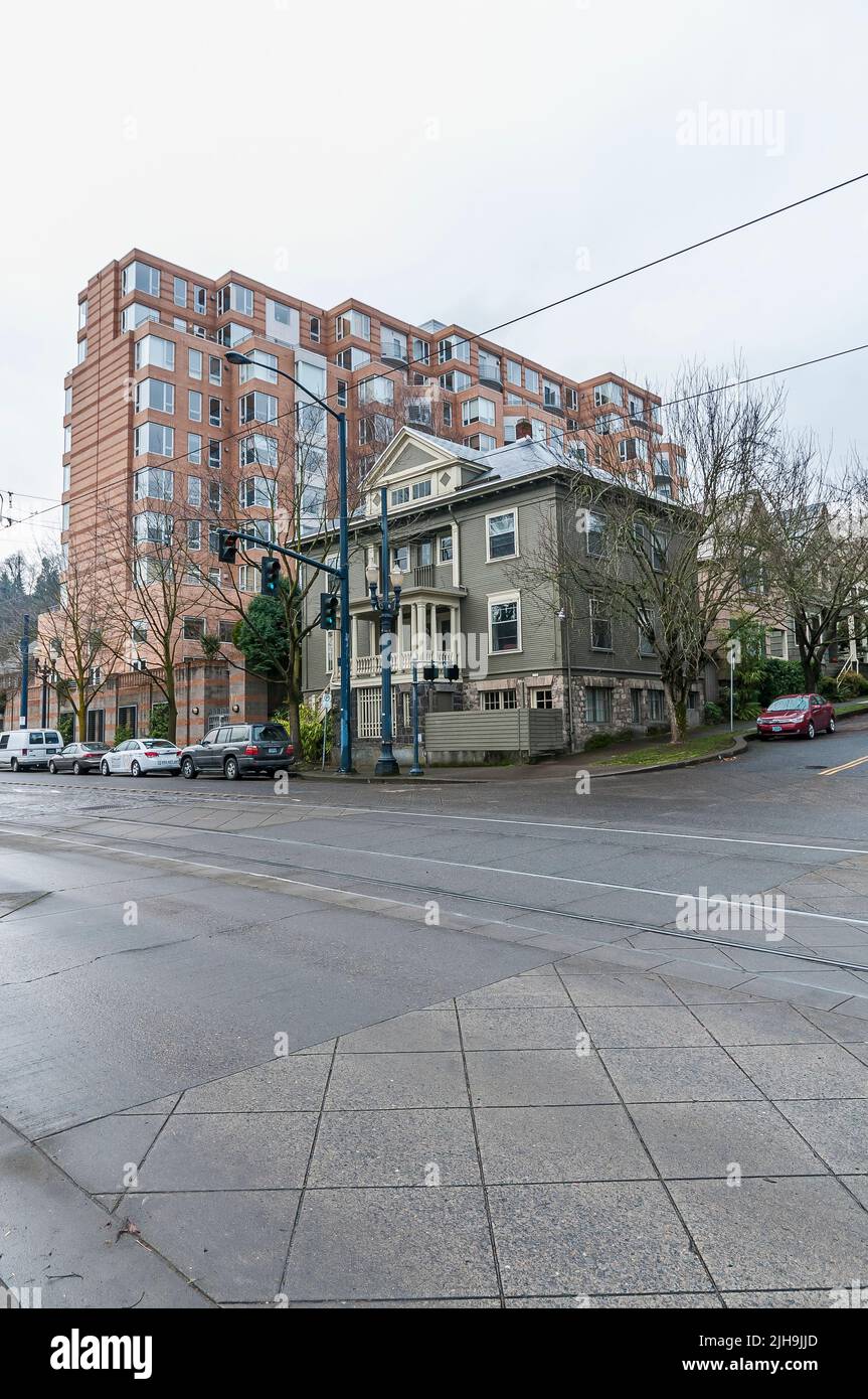 An oldstyle house in front of a modern apartment or condo building in