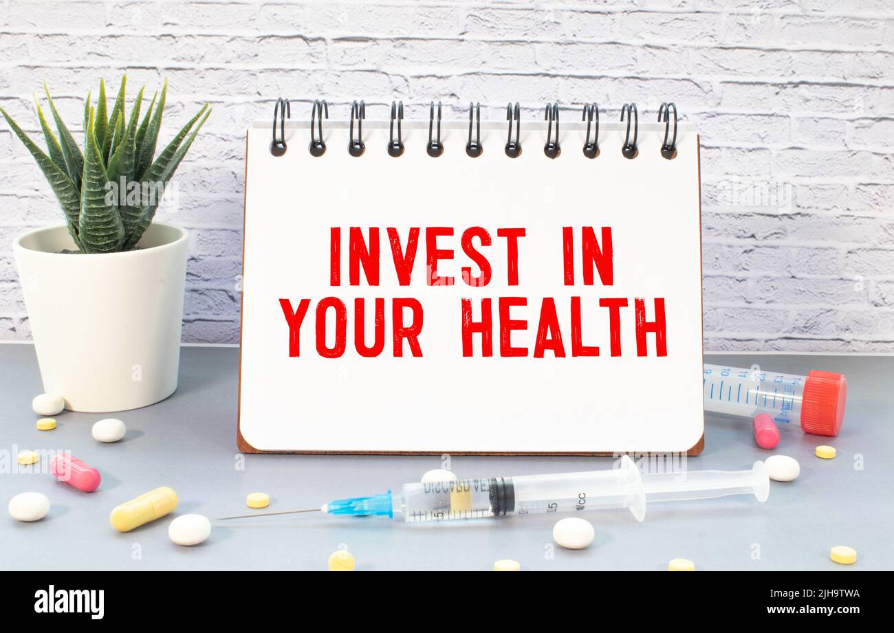 invest in your health advice or reminder - handwriting on an isolated sticky note, wellbeing concept. Stock Photo