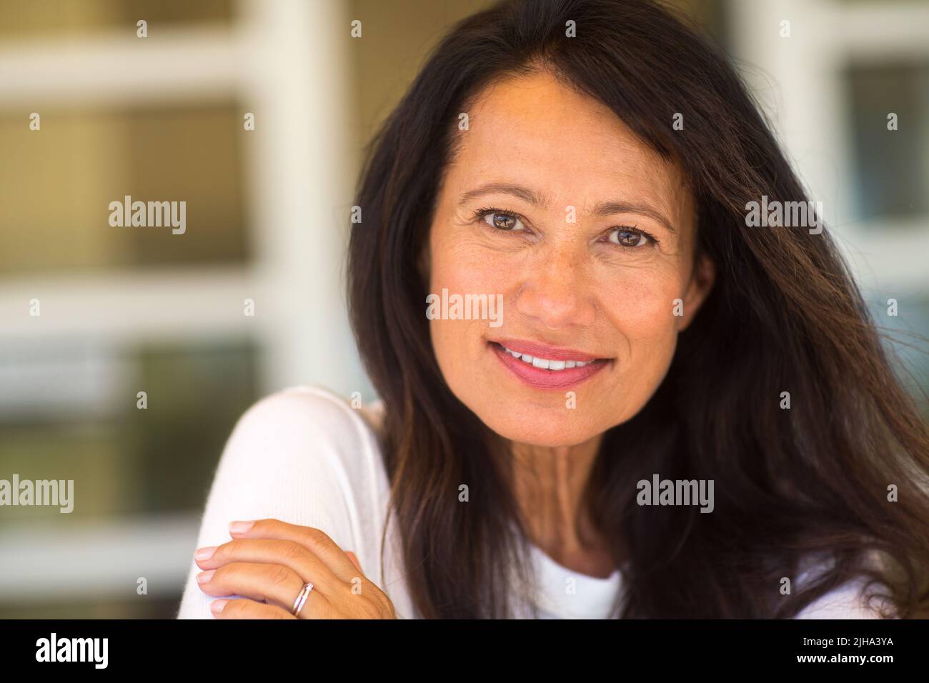 Portrait of a beautiful mature woman sitting on the sofa Stock Photo