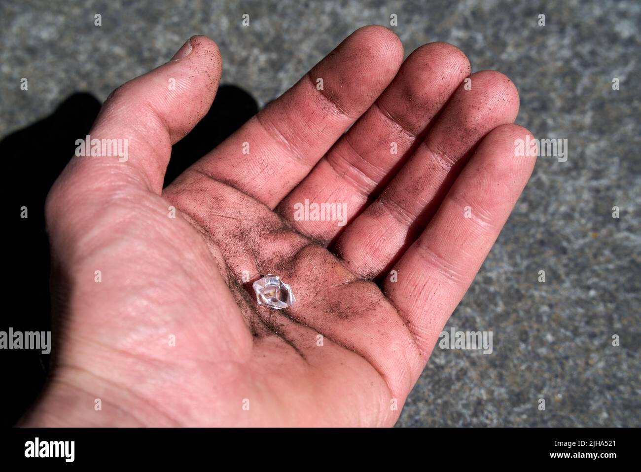 Hand with a simulated diamond pretending to have been found on earth Stock Photo