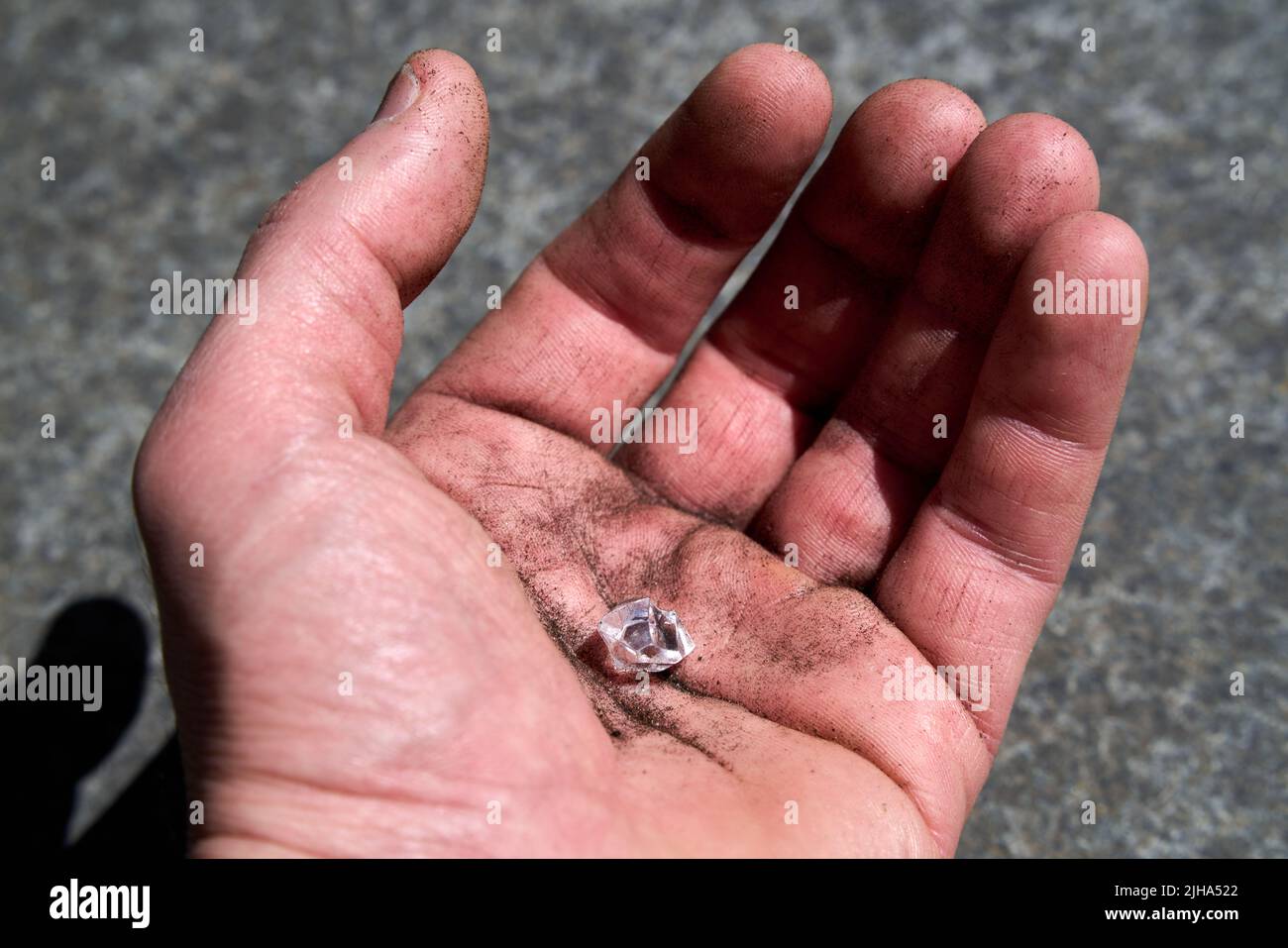 Hand with a simulated diamond pretending to have been found on earth Stock Photo