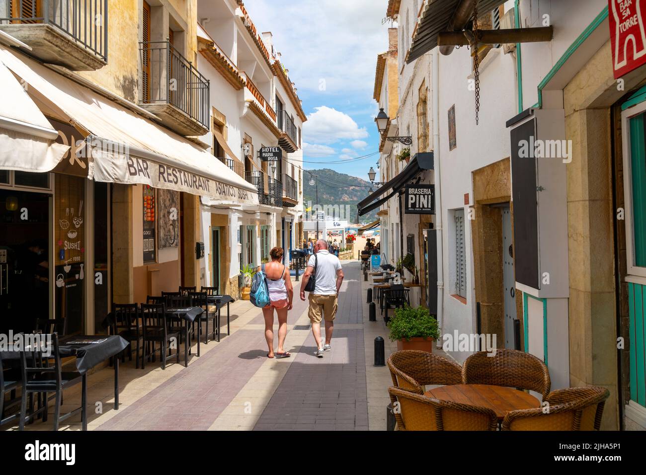 Tourists enjoy sidewalk cafes and shops at the seaside town of Tossa de
