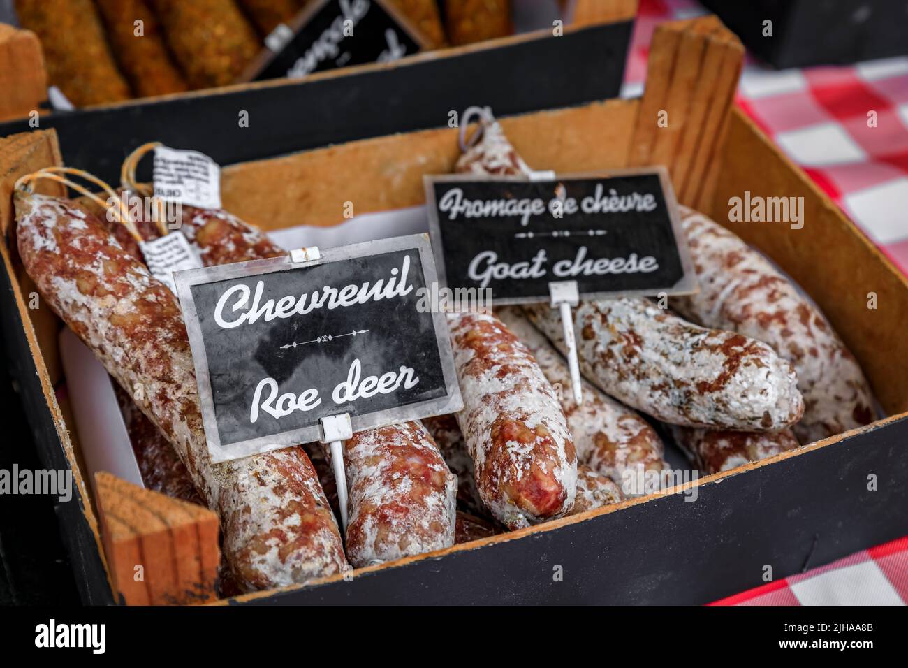 Deer and goat cheese sausage in a basket on a stand at a local farmers market Cours Saleya in Old Town, Vieille Ville in Nice, French Riviera, France Stock Photo