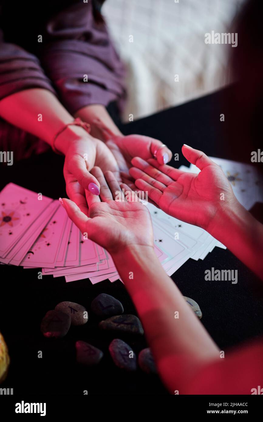 Sorceress reading palm lines for client to tell fortune and predict future life Stock Photo