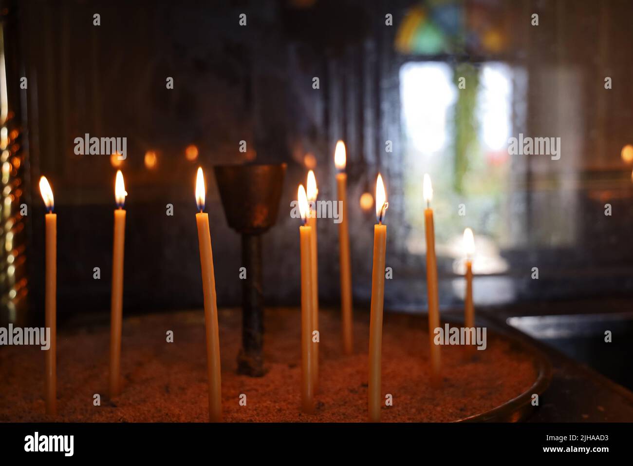 burning candles in the sand in a church Stock Photo