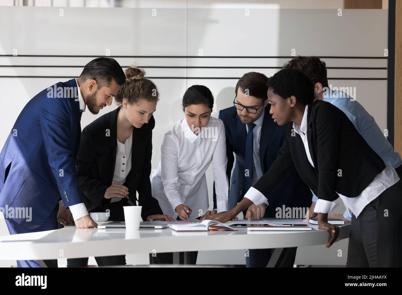 Multiethnic millennial business group of employees discussing project Stock Photo