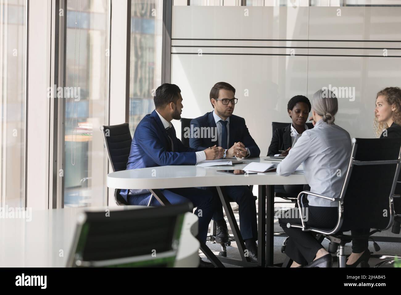 Serious diverse group of business coworkers collaborating on project Stock Photo