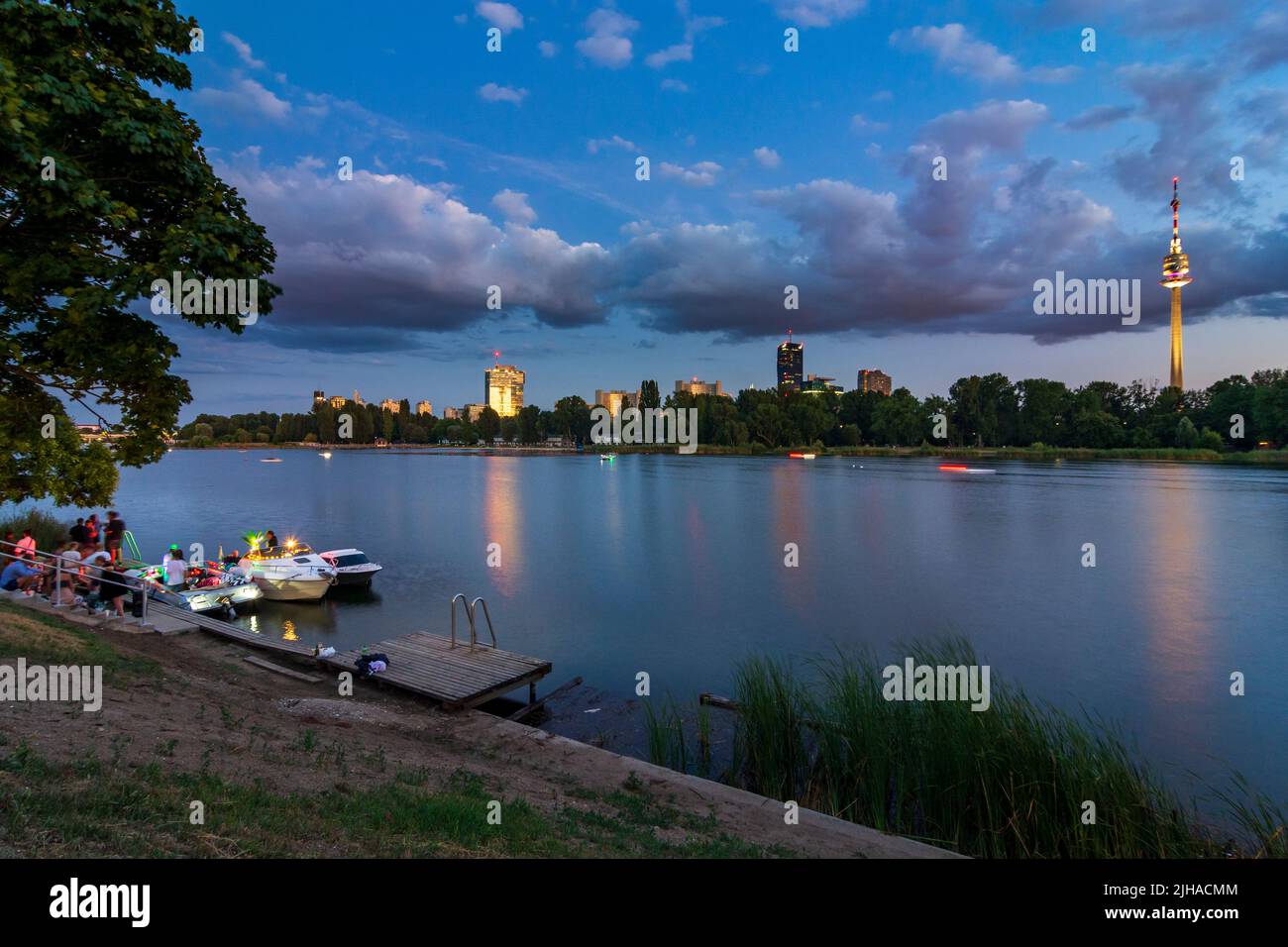 Wien, Vienna: oxbow lake Alte Donau (Old Danube), sunset, privat party on boats, IZD Tower, DC Tower 1, Donauturm (Danube Tower) in 22. Donaustadt, Wi Stock Photo
