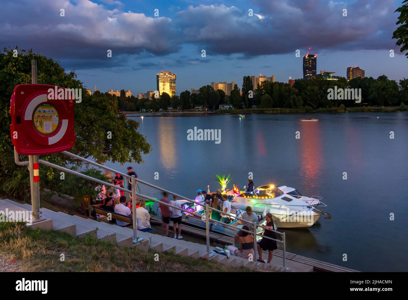 Wien, Vienna: oxbow lake Alte Donau (Old Danube), sunset, privat party on boats, IZD Tower, DC Tower 1 in 22. Donaustadt, Wien, Austria Stock Photo