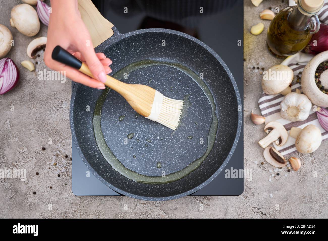 https://c8.alamy.com/comp/2JHAD34/woman-smear-olive-oil-on-frying-pan-with-silicone-brush-at-domestic-kitchen-2JHAD34.jpg