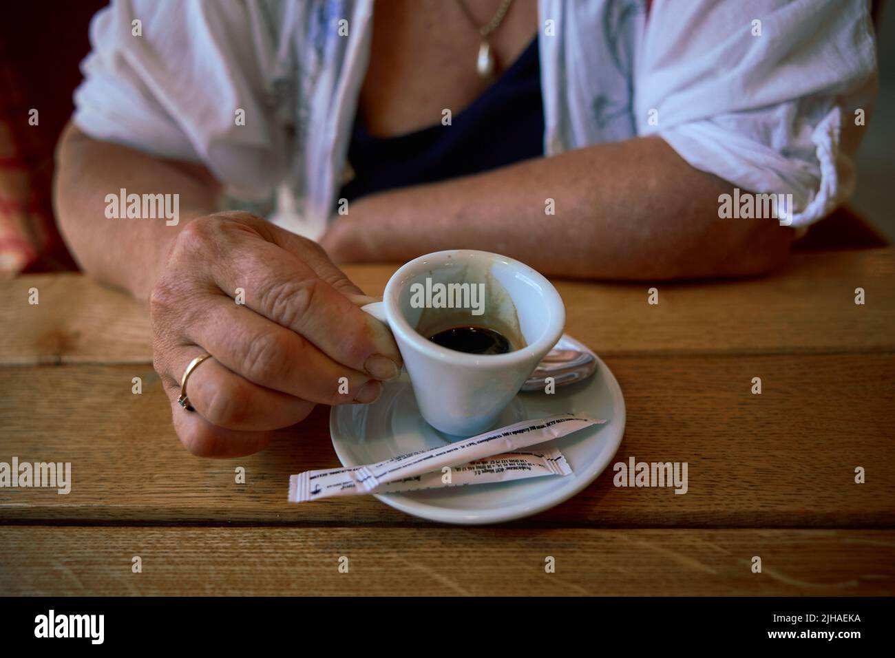 Woman drinking espresso coffee at a restaurant table Stock Photo