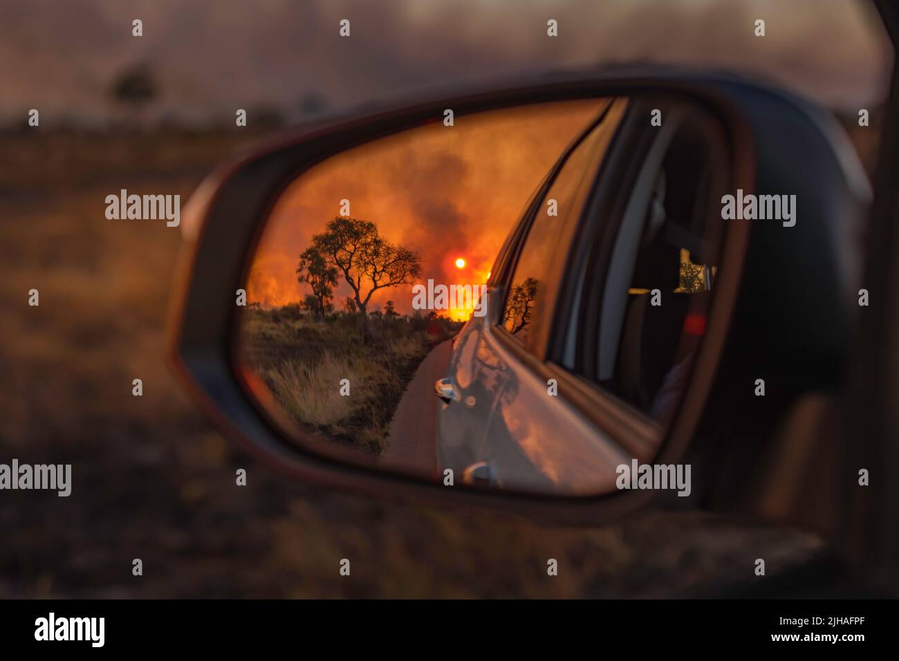 Fire in the veld - Kruger park  back burn- rear vision mirror view Stock Photo