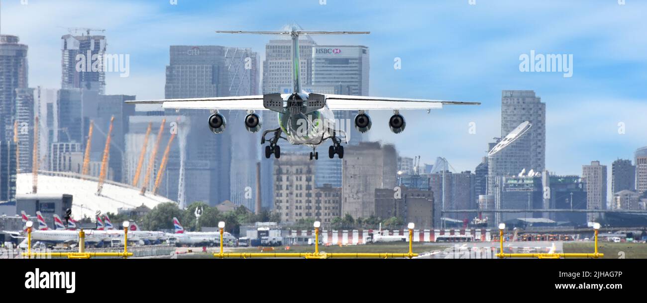 Close up back view four engine passenger aircraft landing at London City Airport O2 arena Canary Wharf in London Docklands beyond Newham England UK Stock Photo