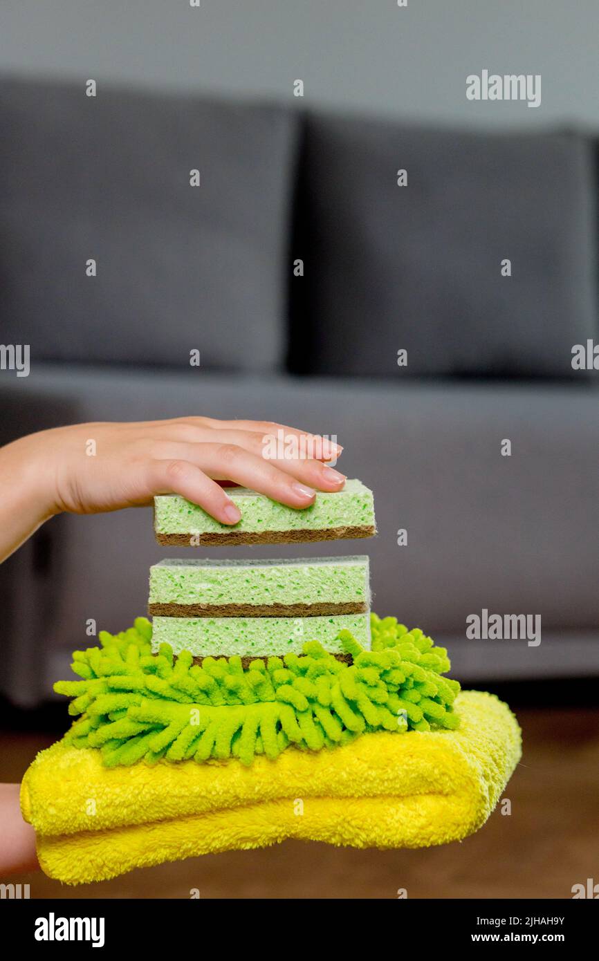 Colored rags and washcloths for manual cleaning on a woman's hand