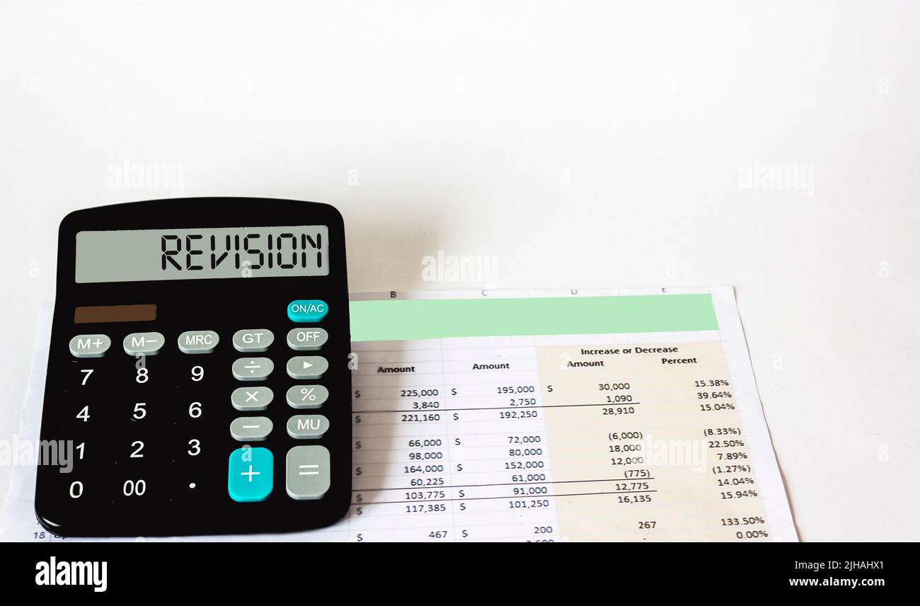 On the white table there is a document and a calculator with Revision written on it. business concept Stock Photo