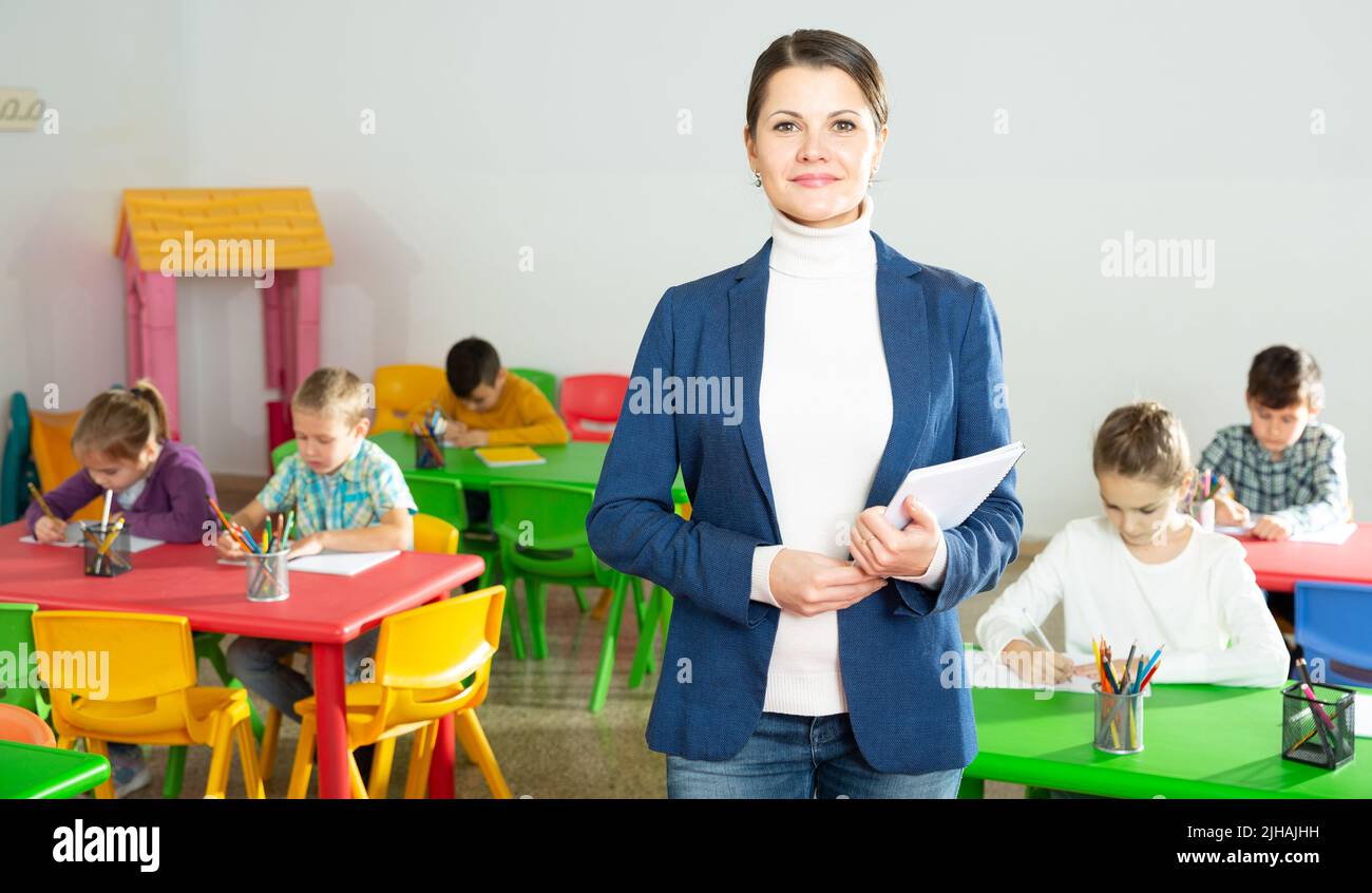 Smiling teacher standing in classroom Stock Photo - Alamy
