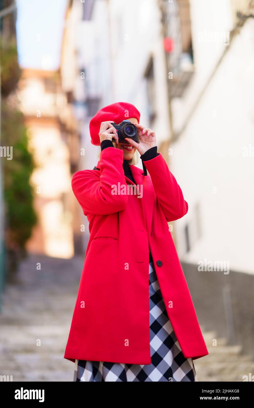 Smiling woman taking pictures on photo camera during holidays Stock Photo