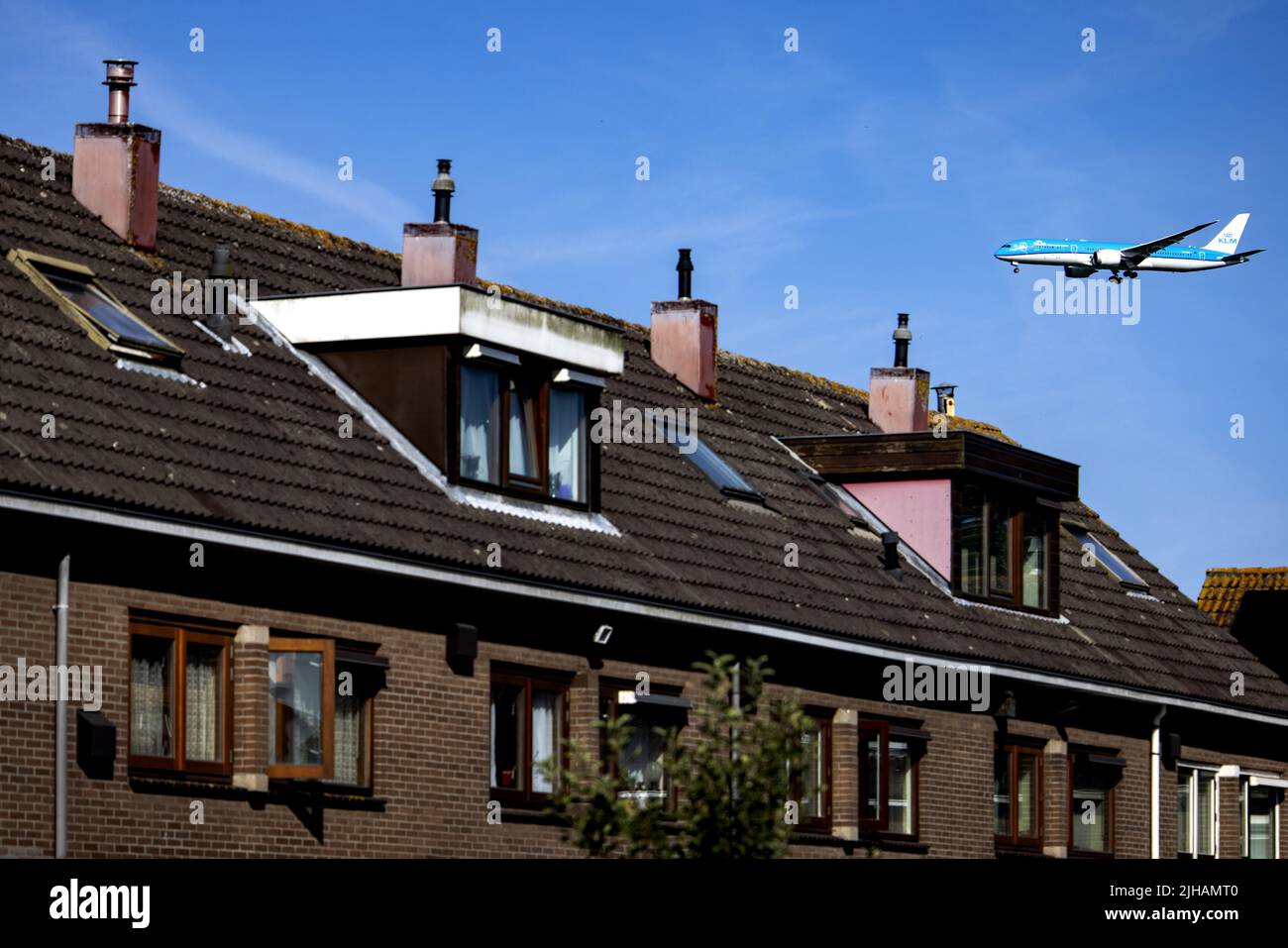 2022-07-17 09:37:05 ZWANENBURG - An airplane flies over a house in the vicinity of Schiphol. Residents near the airport are going to court. They demand that Minister Mark Harbers (Infrastructure and Water Management) put an end to the noise pollution from air traffic at Schiphol. ANP RAMON VAN FLYMEN netherlands out - belgium out Stock Photo