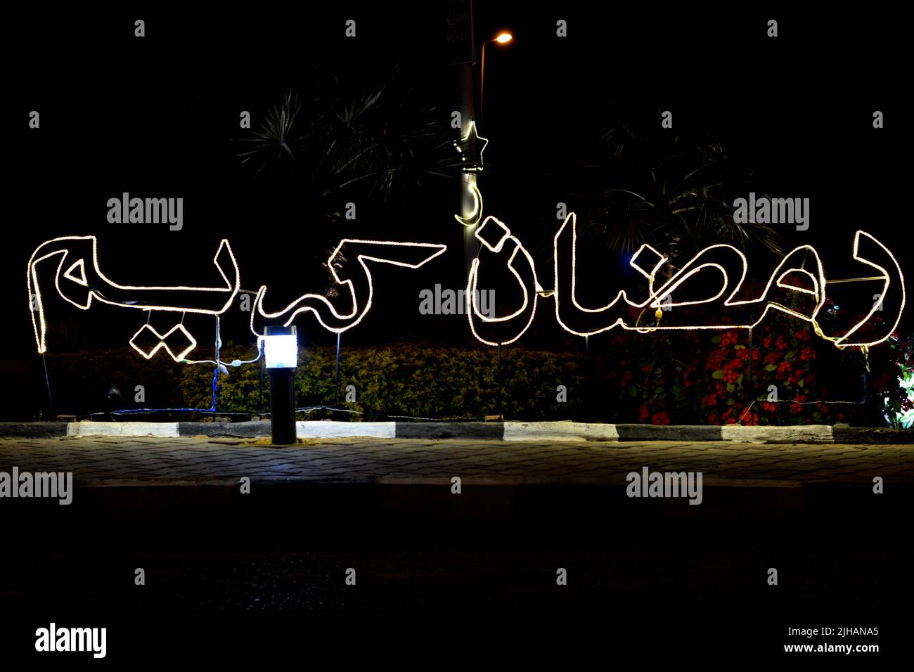 Cairo, Egypt, March 25 2022: An Arabic text Ramadan Kareem, Translation (Generous Happy Ramadan) made with led lights in the street as a festive sign Stock Photo