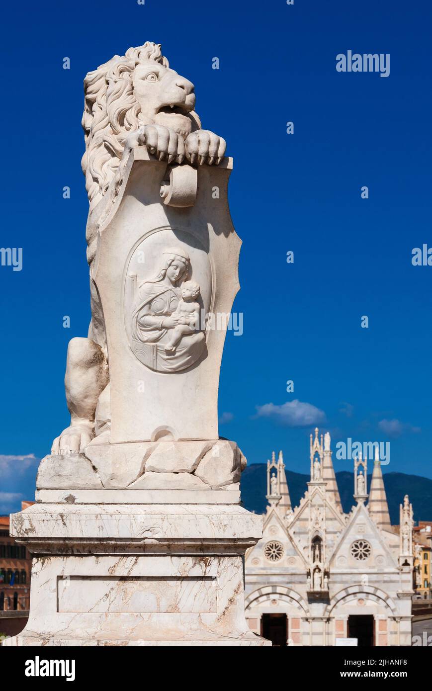 Marble lion statue, erected in 1875 in Pisa historical center, with beatiful St. Mary of the Thorn gothic church in the background Stock Photo