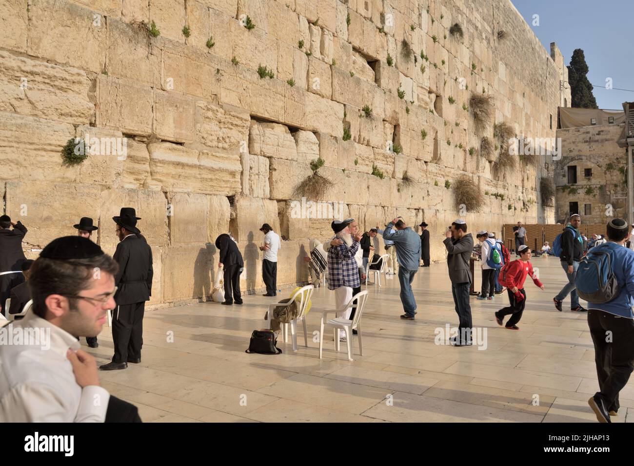 Jerusalem, Israel - March 20, 2014: Jews pray under the Western Wall in the Old city. The Old City is listed as UNESCO World Heritage site since 1981 Stock Photo