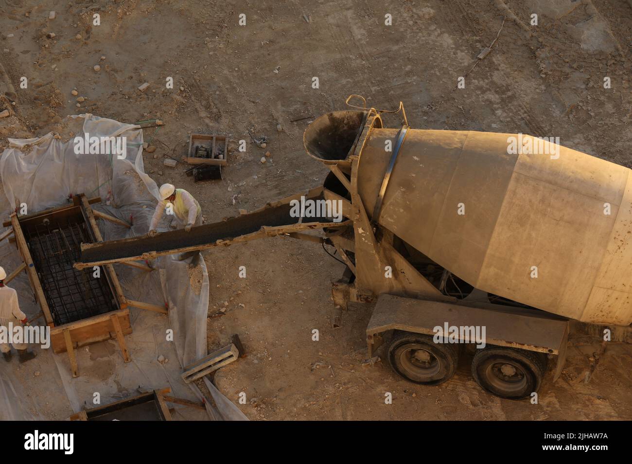 Mixer truck is cement to pouring fresh concrete into a foundation in