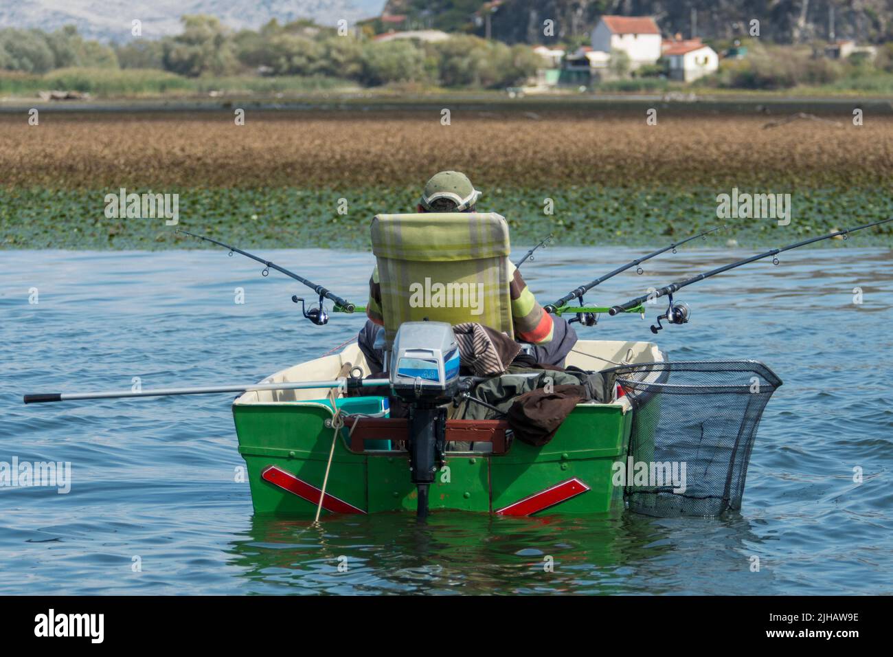 Fisherman in his boat on Skadar lake in Montenegro Stock Photo