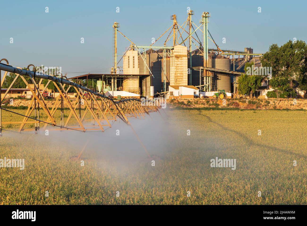 Central pivot irrigation system, irrigation pipes with sprinklers on wheels that rotate on a central axis. Stock Photo
