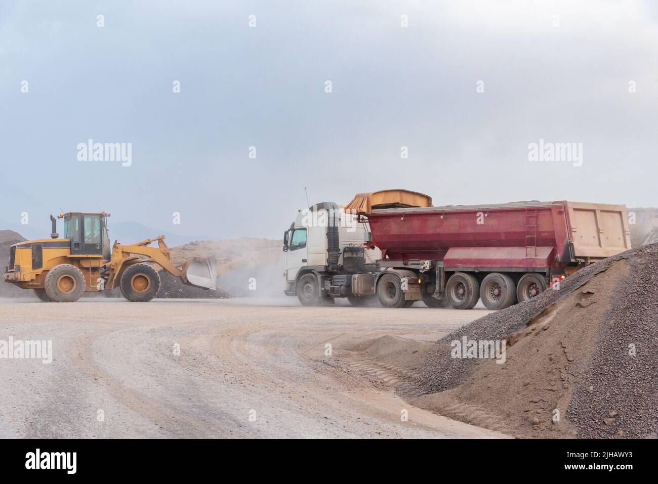 Excavator shovel loading a dump truck in a quarry Stock Photo