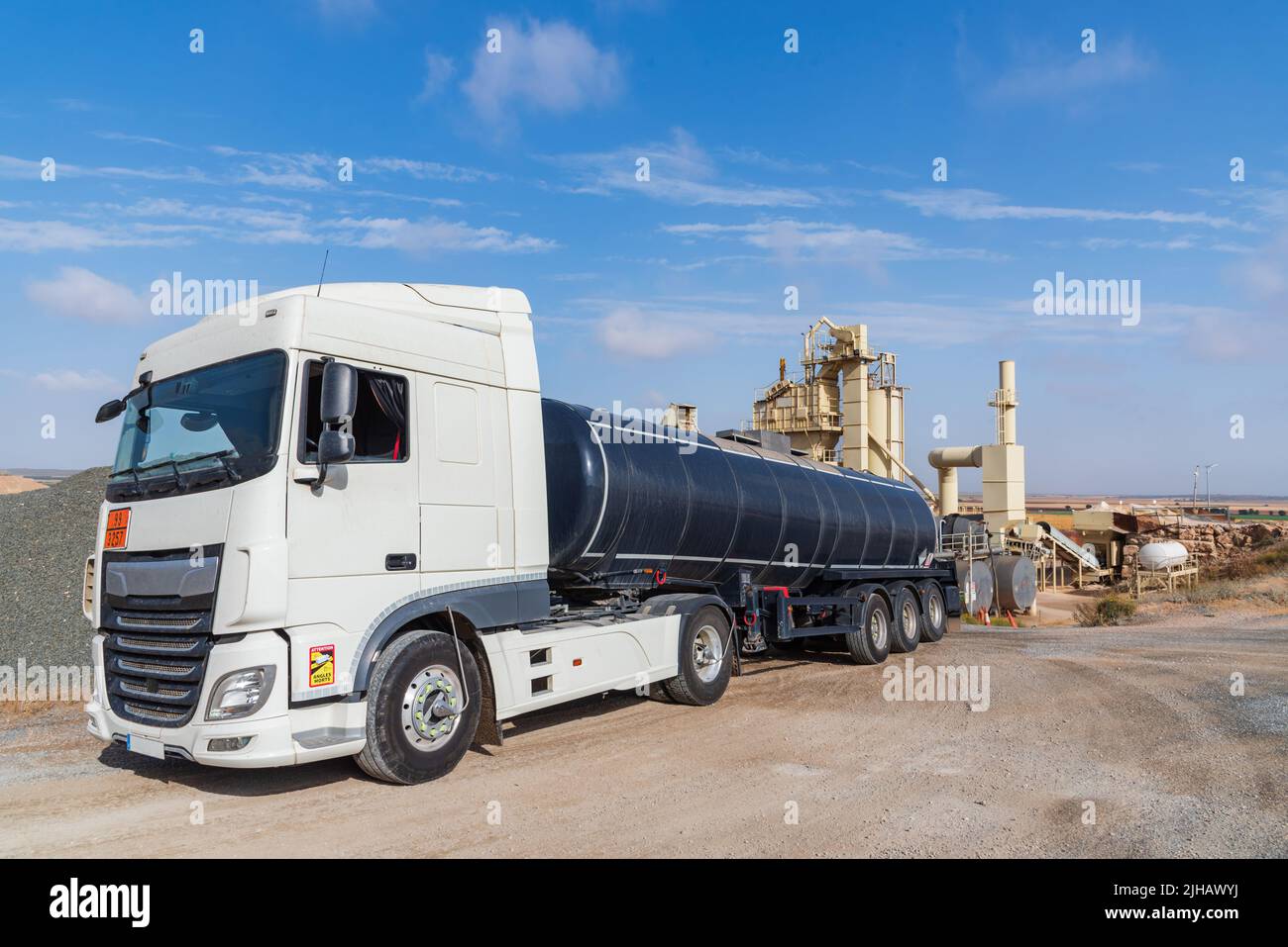 Tanker truck loaded with high temperature bitumen entering an agglomerated asphalt manufacturing plant. Stock Photo