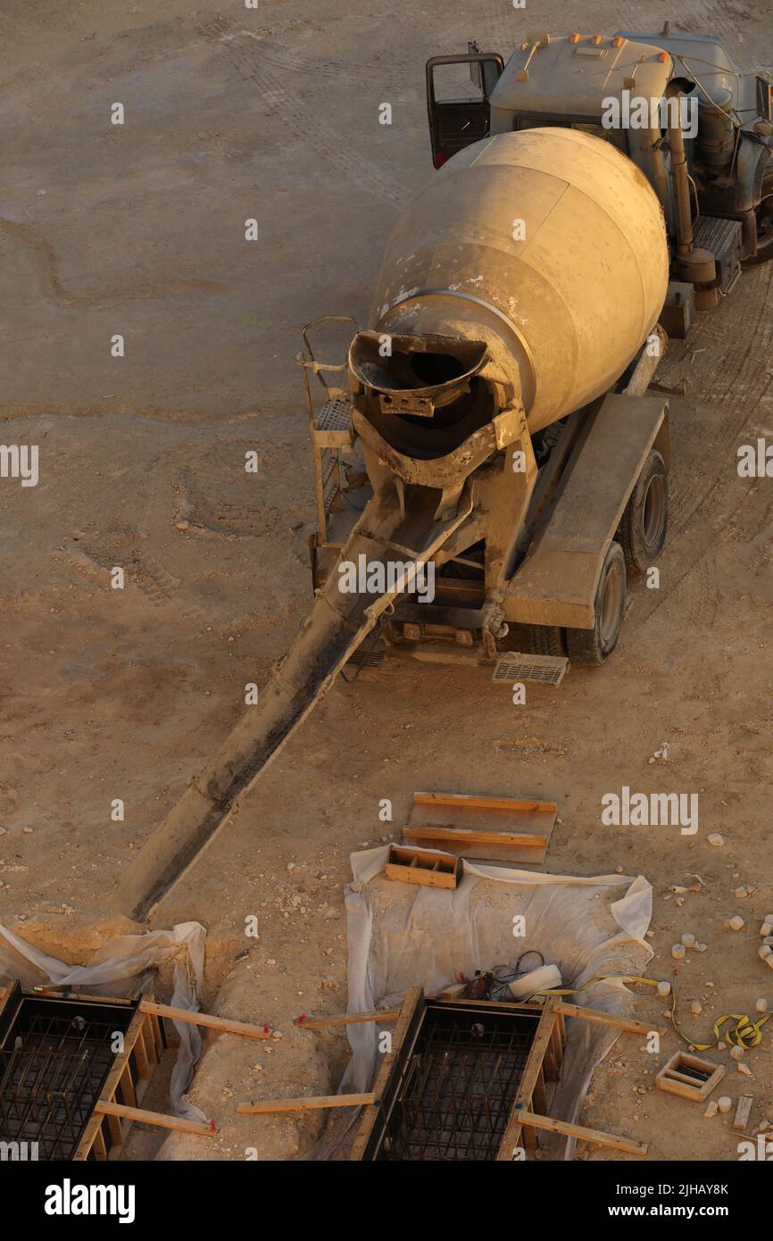 Concrete truck chute pouring wet cement Mix into metal bucket prepare