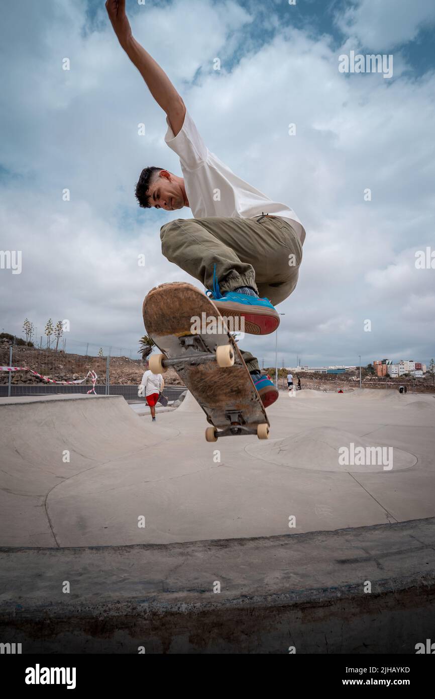 young skateboarder makes a trick called "Fakie noseblunt" in a skate park.  vertical composition Stock Photo - Alamy