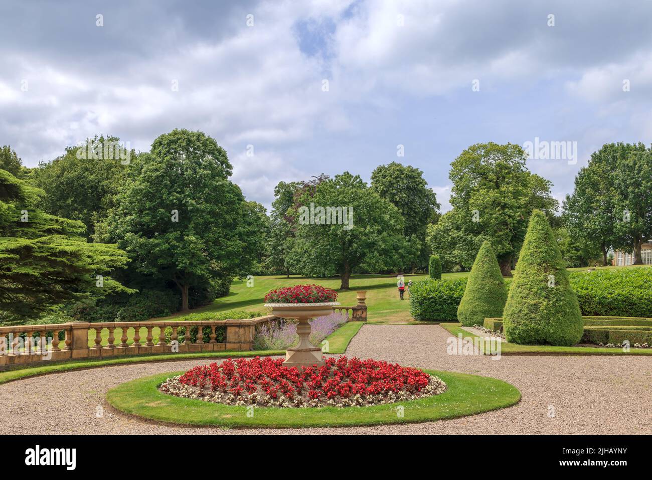 Formal gardens in Tatton Park with stone balustrade, Edwardian tazza planter in the centre of a circular flower bed. Stock Photo