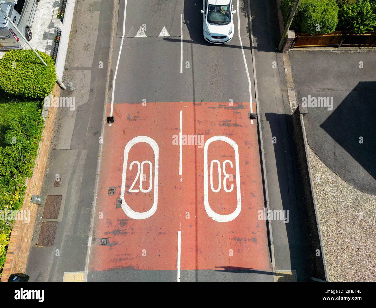 Pontypridd, Wales - July 2022: Aerial view of road markings showing 20 mph and 30 mph speed limits on a country road near a residential area. Stock Photo